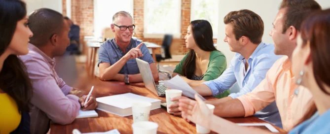 Diverse business team collaborating during a meeting around a table in a modern office.